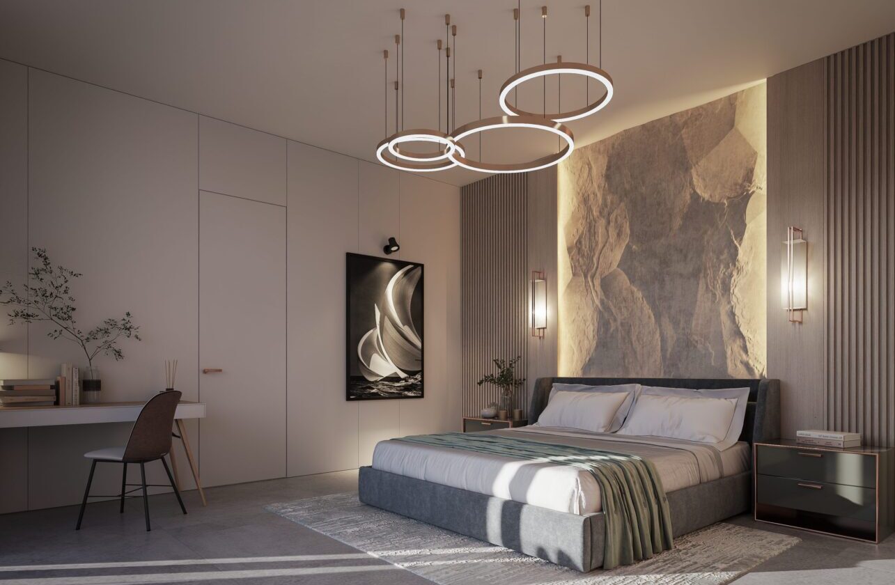 A bedroom with a bed and two lights hanging above it.